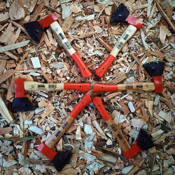 6 reground bahco carving axes lying on a bed of wooden shavings on the workshop floor